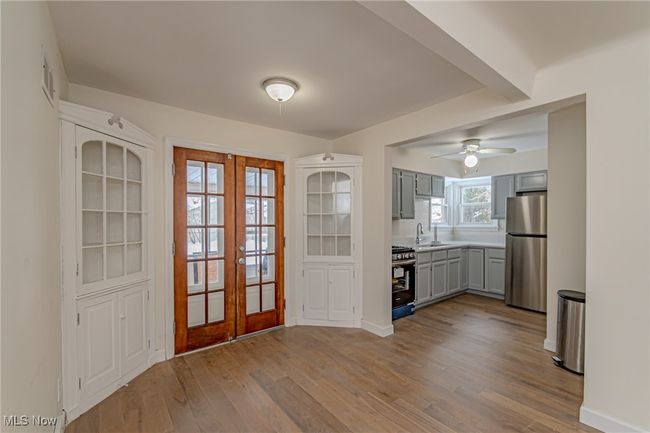 Kitchen featuring gray cabinetry, french doors, ceiling fan, light wood-type flooring, and stainless steel appliances | Image 7