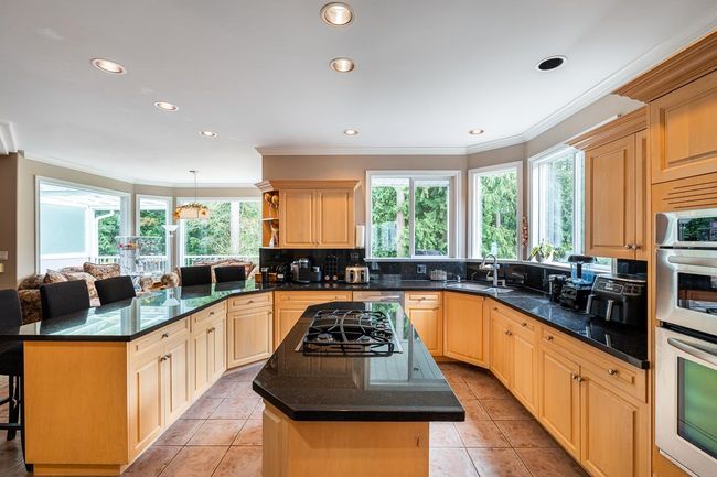 Kitchen featuring a sink, a healthy amount of sunlight, double oven, and a peninsula | Image 12