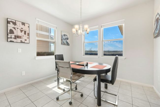 Dining room with light tile patterned floors, baseboards, and a chandelier | Image 12