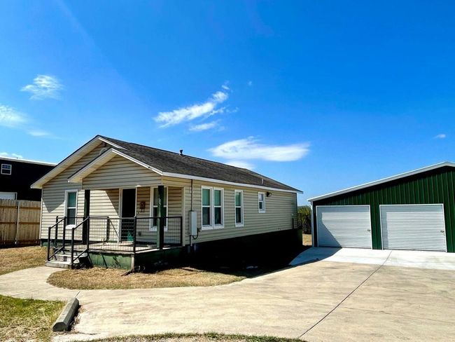 View of front of home with covered porch, a garage, and an outbuilding | Image 14