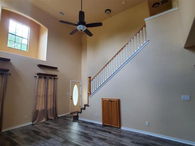 Foyer entrance with dark hardwood / wood-style flooring, ceiling fan, and a towering ceiling | Image 6