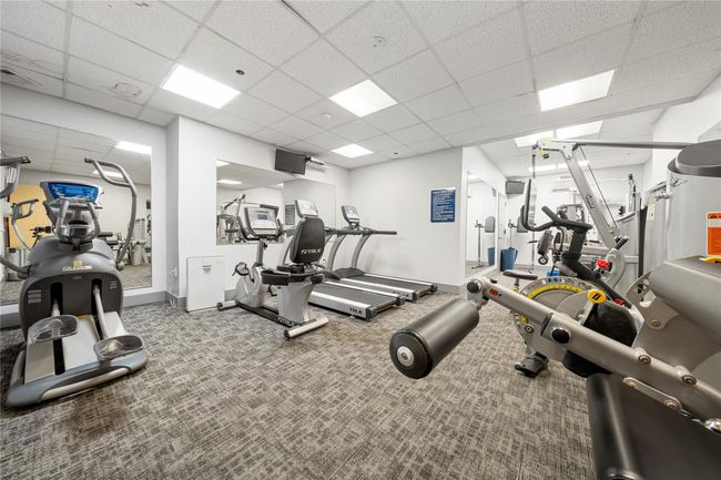 Workout area with a paneled ceiling, baseboards, and carpet floors | Image 19