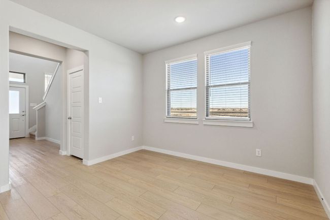 Empty room with baseboards, light wood finished floors, recessed lighting, and stairway | Image 11