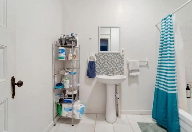 Full bath with tile patterned floors, tasteful backsplash, a sink, and baseboards | Image 5
