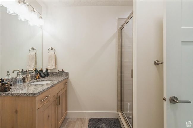Bathroom featuring vanity, a shower stall, and baseboards | Image 25