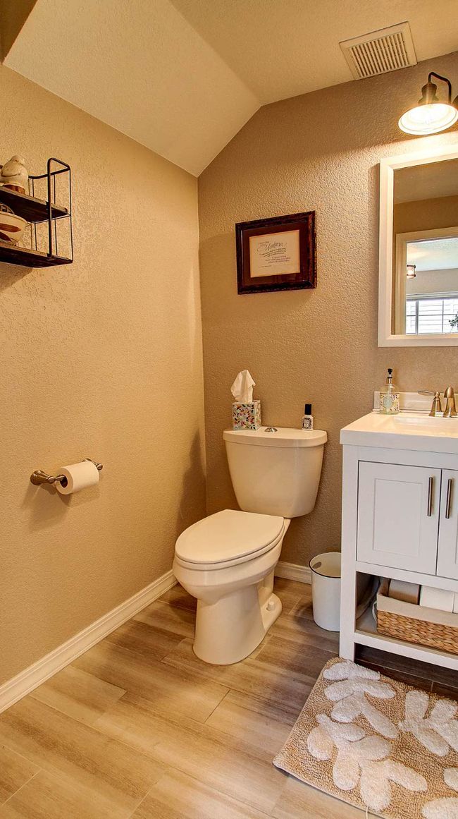 Bathroom with vaulted ceiling, vanity, wood finished floors, and a textured wall | Image 16