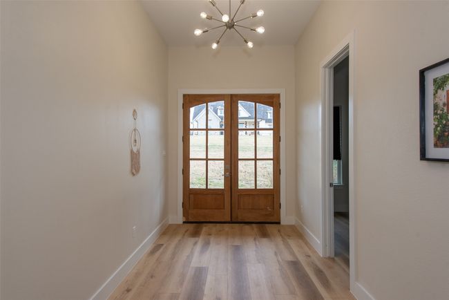 Doorway to outside with french doors, an inviting chandelier, and light wood-type flooring | Image 12
