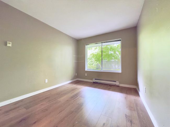 Spare room with a baseboard heating unit, light wood-style floors, and baseboards | Image 9
