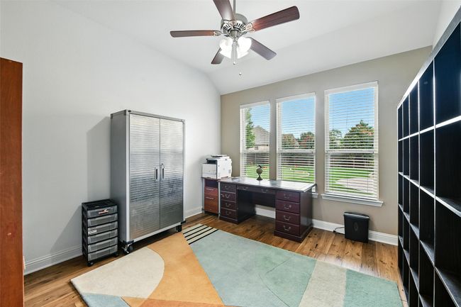 Office space with wood finished floors, ceiling fan, and vaulted ceiling | Image 26