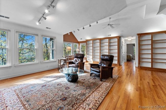 Living area with vaulted ceiling, a ceiling fan, healthy amount of natural light, wood finished floors, and rail lighting | Image 47