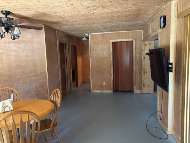 Dining room featuring wood walls and a ceiling fan | Image 10