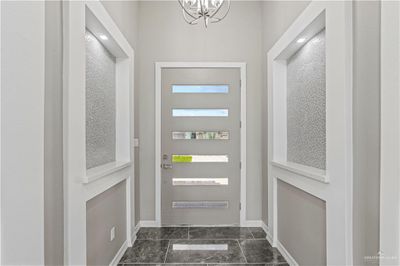 Doorway with a notable chandelier and dark tile patterned flooring | Image 3