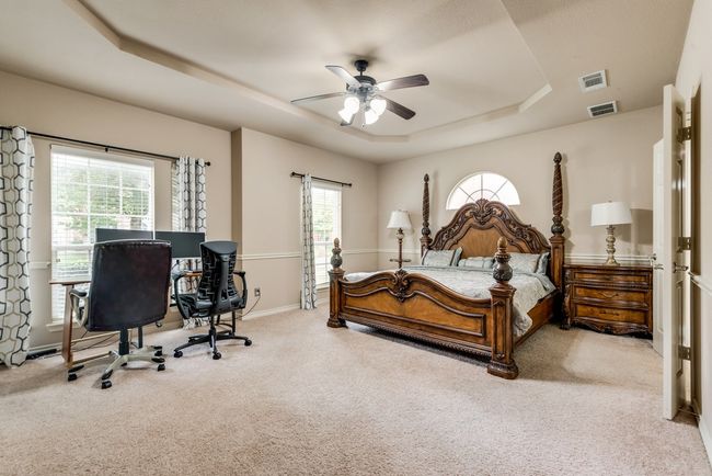 Bedroom featuring a tray ceiling, carpet flooring, a desk, and a ceiling fan | Image 11