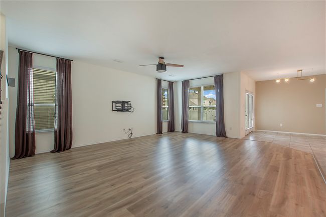 Empty room with ceiling fan and light wood finished floors | Image 7