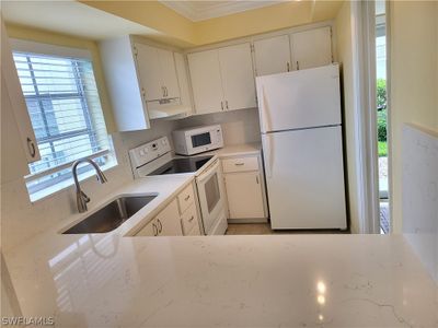 Kitchen with new sink Quartz counter tops and back splash and white cabinetry | Image 3