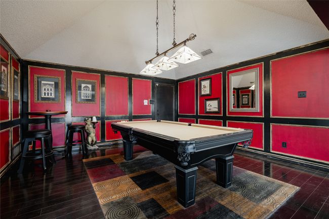 Game room with a textured ceiling, vaulted ceiling, wood finished floors, and pool table | Image 9
