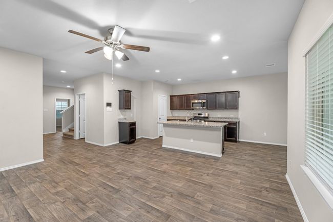 A beautiful granite counter top kitchen that opens into a large family/living room with views of the covered patio. | Image 14