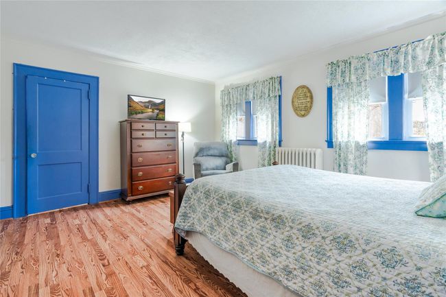 Bedroom featuring ornamental molding, radiator heating unit, and light wood-type flooring | Image 21