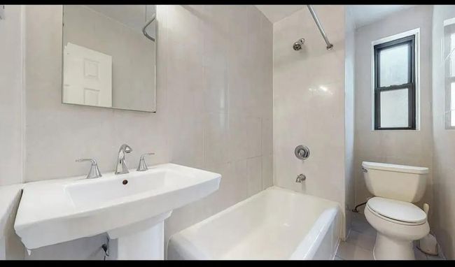 Bathroom with toilet, shower / bathtub combination, and a sink | Image 8