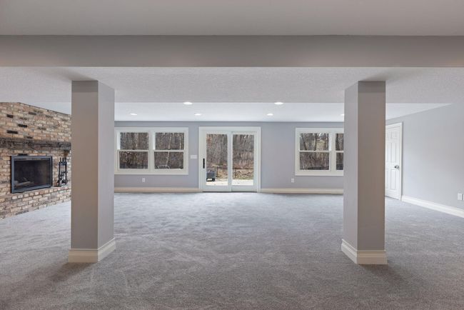 Lower level Family Room has sliding glass doors to walk out to the backyard and has a wood burning fireplace. | Image 27
