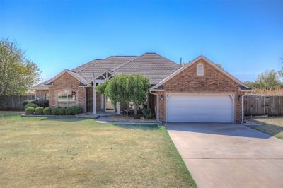 View of front facade featuring a front yard and a garage | Image 1