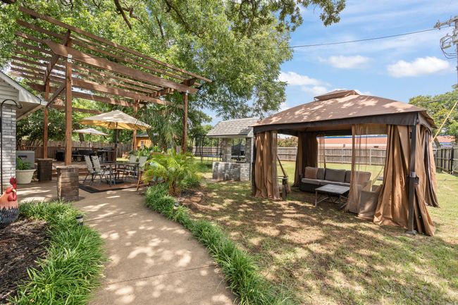 View of yard with a gazebo, a pergola, a patio area, and an outdoor hangout area | Image 23