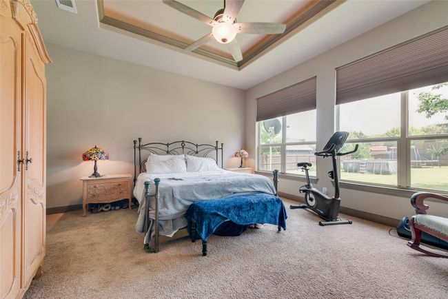 Carpeted bedroom with a tray ceiling and a ceiling fan | Image 26