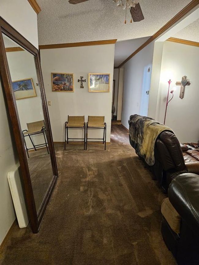 Corridor with carpet floors, a textured ceiling, and crown molding | Image 28