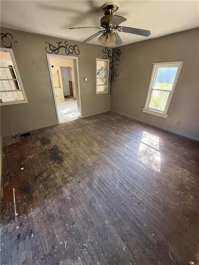 Unfurnished living room with wood-type flooring and ceiling fan | Image 3