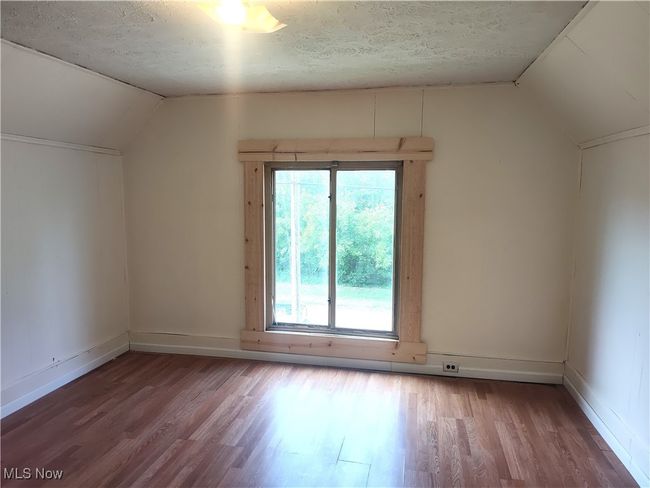 Bonus room featuring vaulted ceiling, wood finished floors, a textured ceiling, and baseboards | Image 38