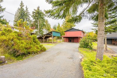 View looking down the main driveway. Double carport adjacent to the home and another carport with storage above to the left. Room on either side for a boat and RV, etc. | Image 3