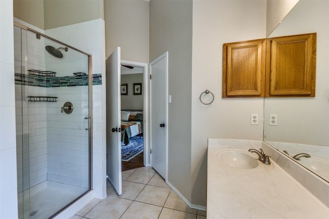 Bathroom featuring a stall shower, tile patterned flooring, ensuite bathroom, and vanity | Image 15