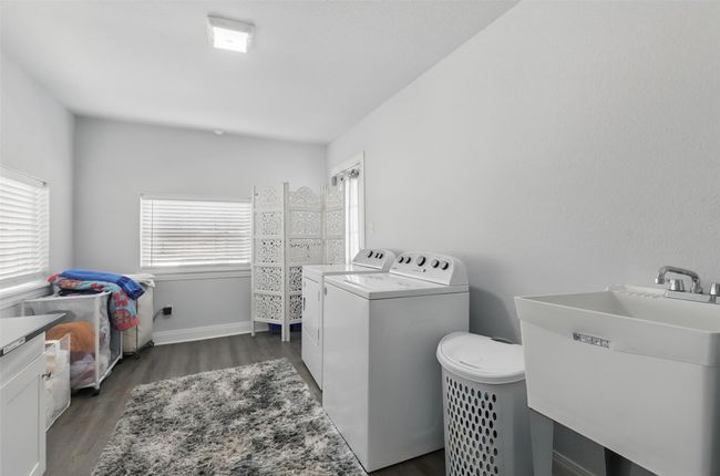 Laundry area with washing machine and dryer, dark wood-style floors, and baseboards | Image 21