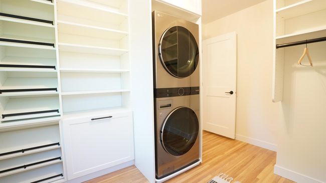 Besides the brand new cabinetry, built-hampers, refinished white oak floors and new lighting, this owners' closet also offers upper level laundry. This brand new LG wash tower is both sophisticated, whisper quiet and convenient. | Image 18