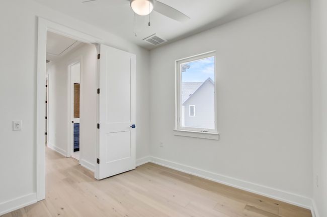Empty room with attic access, ceiling fan, light wood-style flooring, and baseboards | Image 27