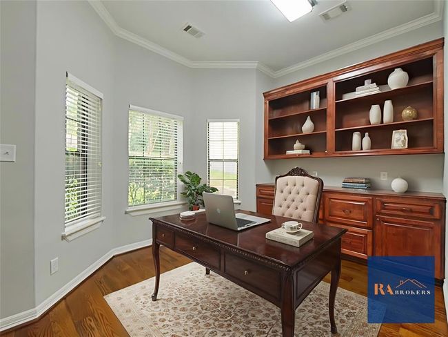 Discover the inviting home office just off the entrance, featuring elegant built-in cabinets and bookshelves. This room could also be used as a fourth bedroom with the closet that is included. (virtually staged) | Image 5