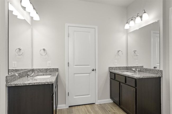 Bathroom with a sink, two vanities, baseboards, and wood tiled floor | Image 21