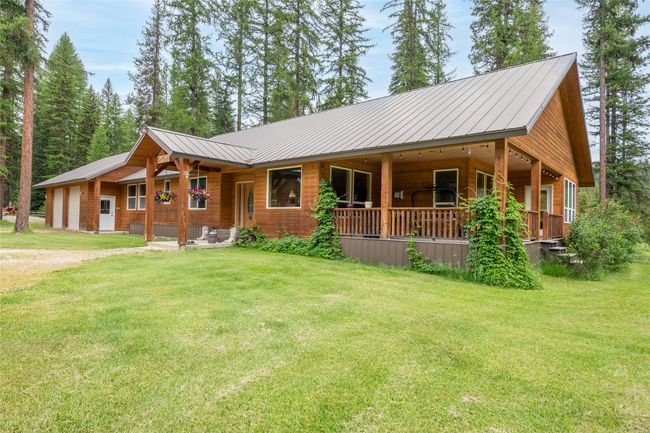 View of front of house featuring covered porch, a front yard, and a metal roof | Image 23