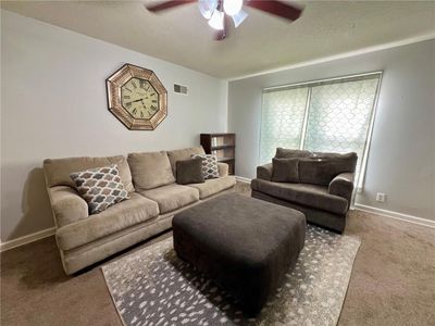 Carpeted living room with ceiling fan and a textured ceiling | Image 3