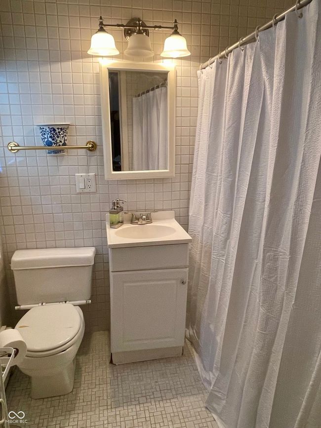 full bath for bedroom 2 featuring vanity, tile walls, tile patterned flooring, and curtained shower | Image 34