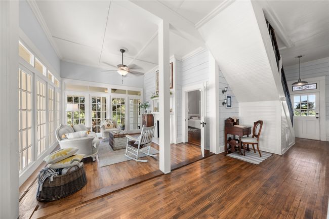 Sunroom / solarium featuring wood-type flooring, wood walls, and french doors | Image 12