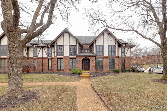 Tudor home featuring stucco siding, a front yard, and brick siding | Image 48