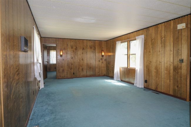 Carpeted empty room with wood walls | Image 13