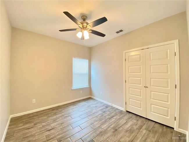 Unfurnished bedroom featuring wood finished floors, a closet, baseboards, and a ceiling fan | Image 5