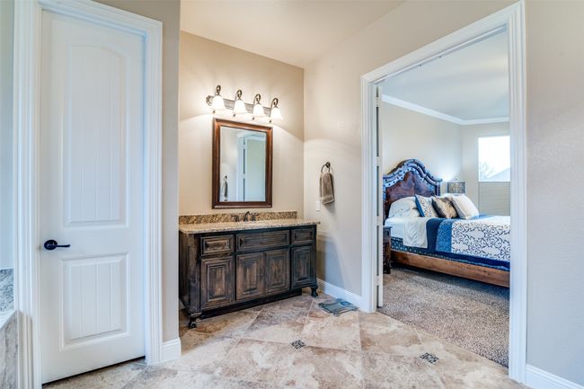 The separated vanity spaces feature a designer mirror and lighting, oil-rubbed bronze faucets and oval undermount sinks. There is a private toilet room in the ensuite. | Image 22