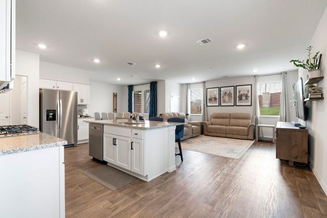 Kitchen featuring appliances with stainless steel finishes, dark wood-style floors, a kitchen bar, white cabinets, and open floor plan | Image 14