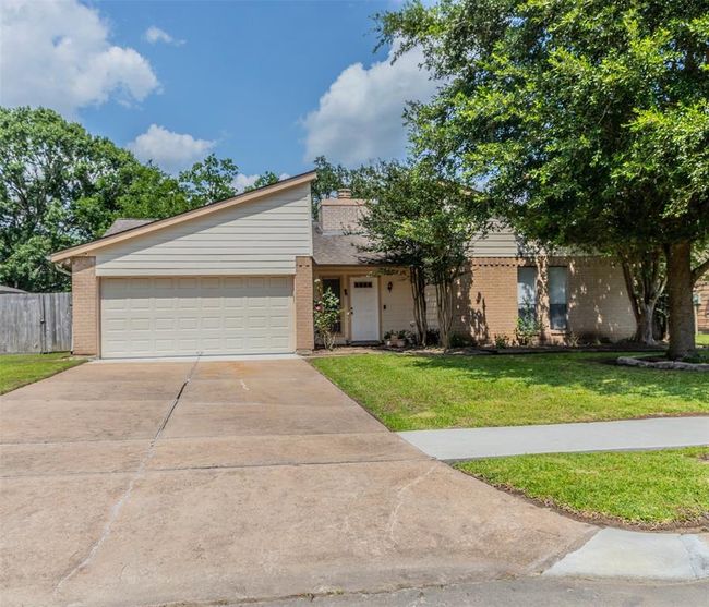 Charming single-story home with a two-car garage, set on a spacious lot with mature trees and a well-maintained lawn. The exterior features a combination of brick and siding, offering great curb appeal. | Image 4