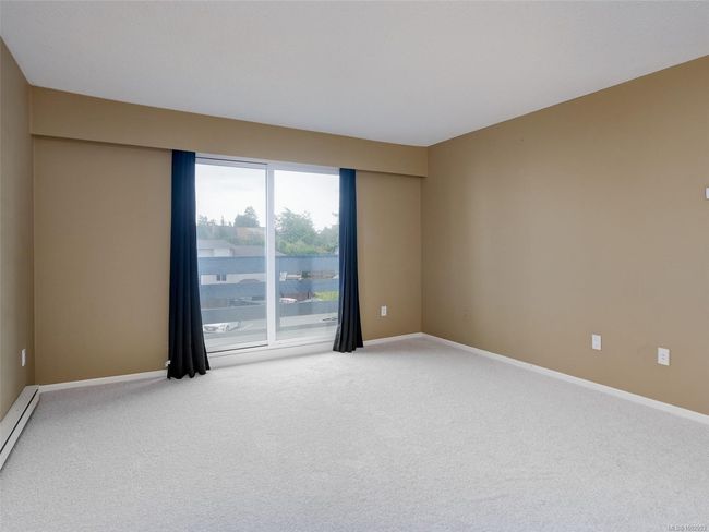 Carpeted spare room featuring baseboards and baseboard heating | Image 4