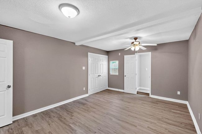 Unfurnished room with wood finished floors, ceiling fan, and a textured ceiling | Image 16