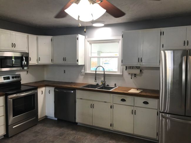 Kitchen with a ceiling fan, wooden counters, stainless steel appliances, and a sink | Image 6